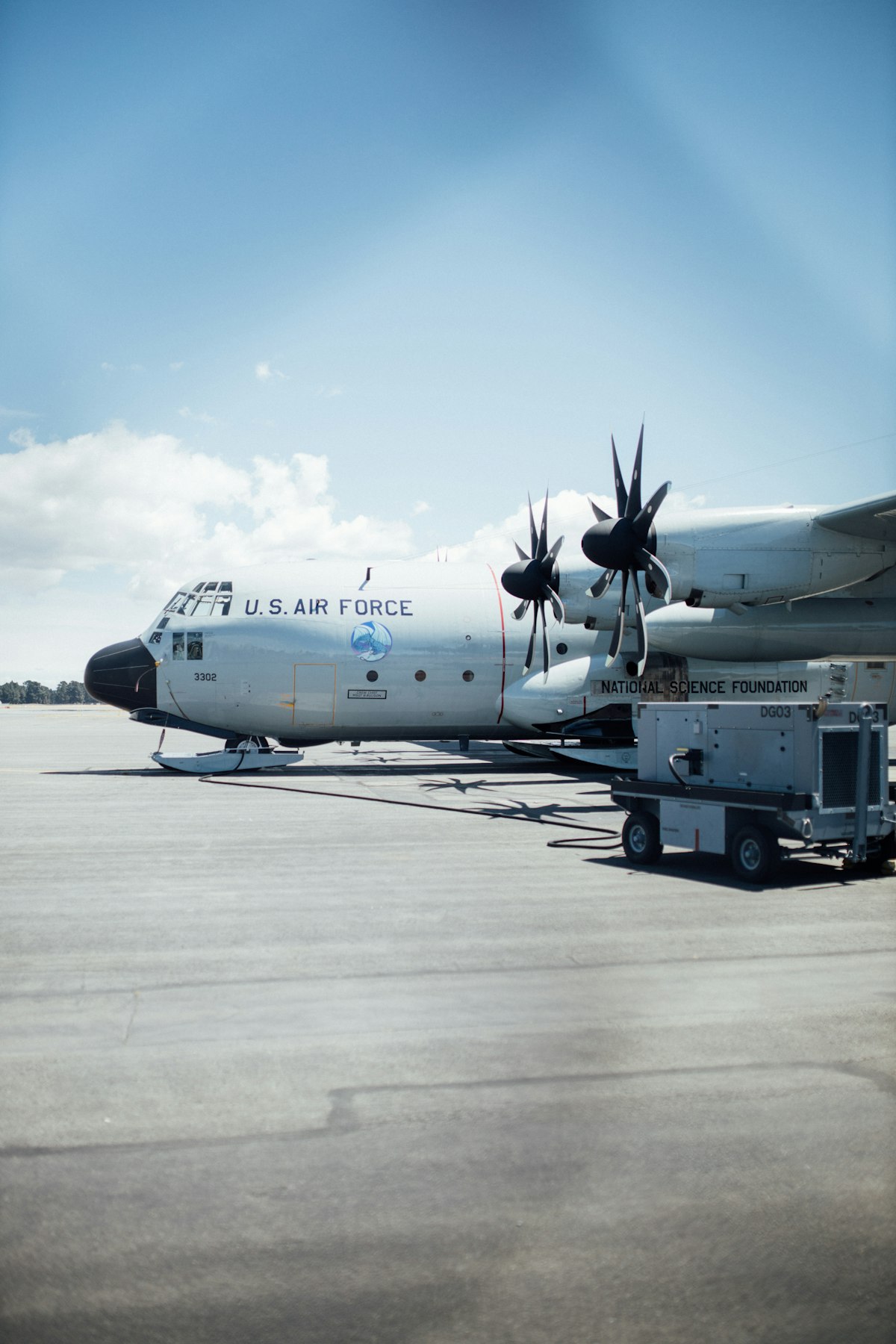 U.S. Air Force C-130 Hercules on the ramp with ground support equipment, representing the tactical airlift platform for Air Force loadmasters
